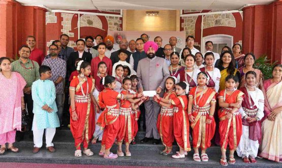 The Governor presenting cheques to young girls on the occasion of the program held at Lok Bhavan to celebrate the State Foundation Days of Rajasthan and Odisha.