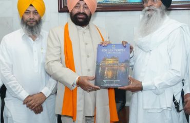 A member of the Gurdwara committee presenting a book to the Governor at Sri Harmandir Sahib in Amritsar.
