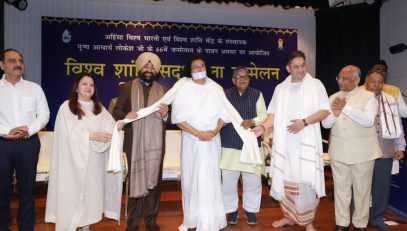 The Governor presenting a shawl and extending birthday wishes to Acharya Lokesh Muni Ji on the occasion of the "World Peace and Harmony Conference," organized by Ahimsa Vishwa Bharti .