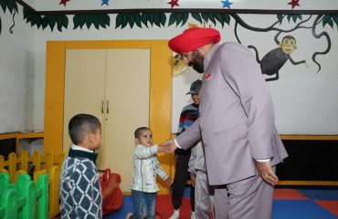 The Governor engaging in a warm interaction with young children during a tour of the Garhwal Rifles Regimental Centre.