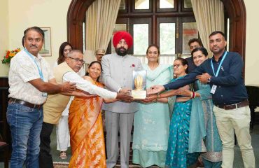 Governor presenting memento to the officials of SOS Bal Gram, Bhimtal at Lok Bhavan.