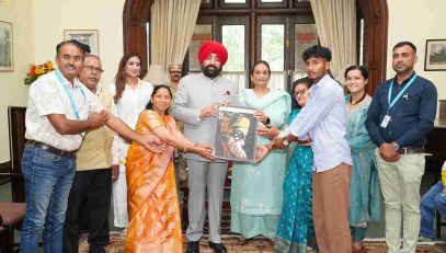 Officials of SOS Bal Gram, Bhimtal presenting photo frame to the Governor at Lok Bhavan.