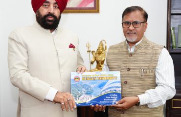 Vice-Chancellor Prof. Diwan S. Rawat presenting a coffee table book showcasing the university's achievements and innovations to the Governor.