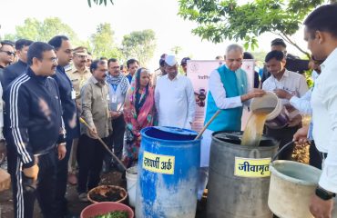 Governor demonstrating the preparation of Jivamrut to farmers