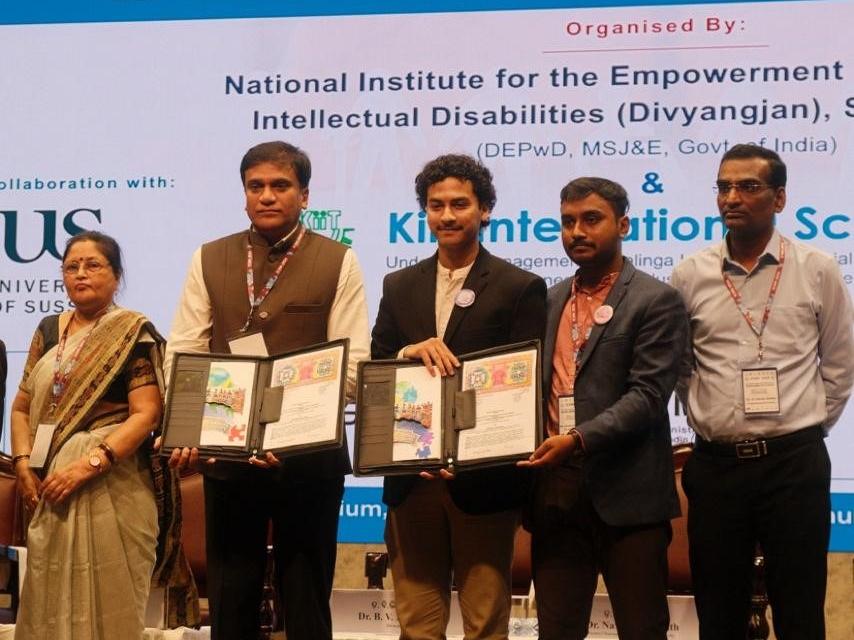 The Daira and NIEPID teams holding the signed MoU folders on stage at the International Conference on Building Bridges for Inclusivity