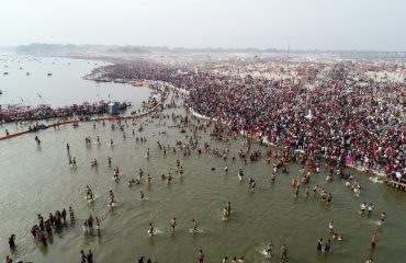 तीर्थयात्री गंगा नदी के पवित्र जल में डुबकी लेते हुए