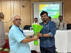 Dr. Akhilesh Shukla presenting a bouquet to the chief guest at a seminar on cleanliness