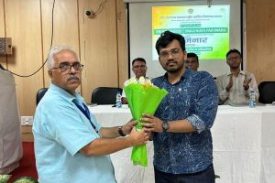 Dr. Akhilesh Shukla presenting a bouquet to the chief guest at a seminar on cleanliness