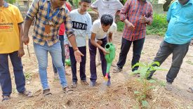 Students watering the gardening raised bed