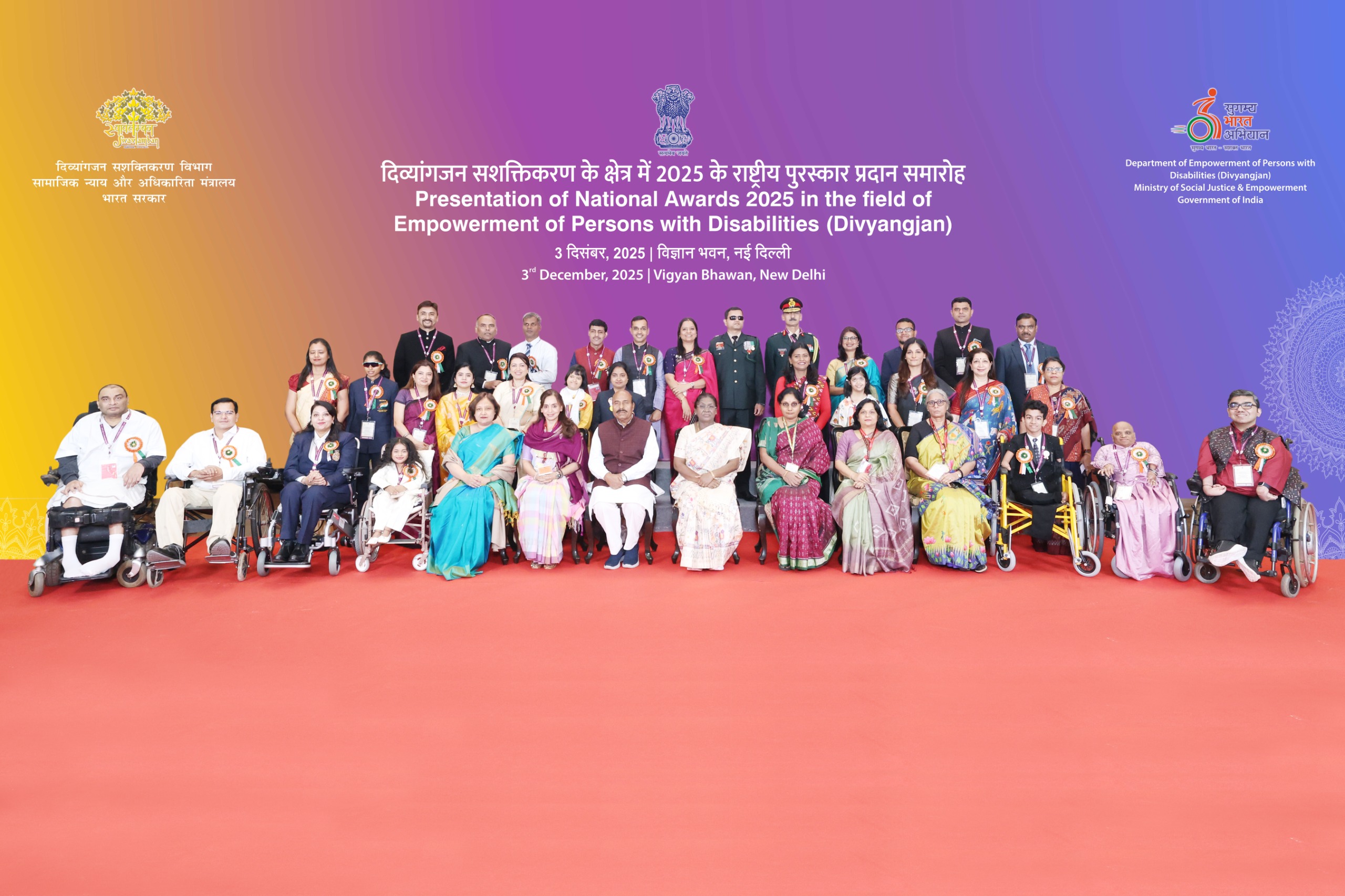 This is a group photograph in which, in the front row at the center, are seated the Hon’ble President of India, Smt. Droupadi Murmu; Union Minister for Social Justice and Empowerment, Dr. Virendra Kumar; Secretary, Department of Empowerment of Persons with Disabilities, Smt. V. Vidyavathi; Additional Secretary Smt. Manmeet Kaur Nanda; Joint Secretary Smt. Sumita Singh; Joint Secretary Ms. Debolina Thakur; and Deputy Director General Smt. Richa Shankar. In the second row are the National Awards 2025 awardees.