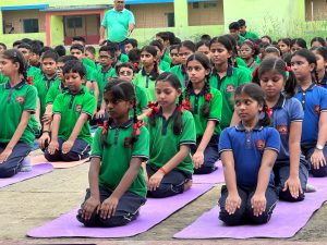 Large group performing yoga exercises in an open area