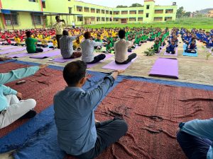 Students and staff performing yoga together during Yoga Day celebration