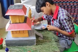 Student coloring a multistorey house