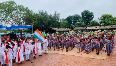प्राथमिक विद्यालय के छात्र झंडा लहराते हुए