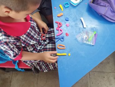 class one student making clay alphabets