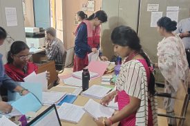 शिक्षक परीक्षा विभाग में पेपर एकत्र कर रहे हैं।