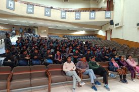 teacher with students in auditorium hall